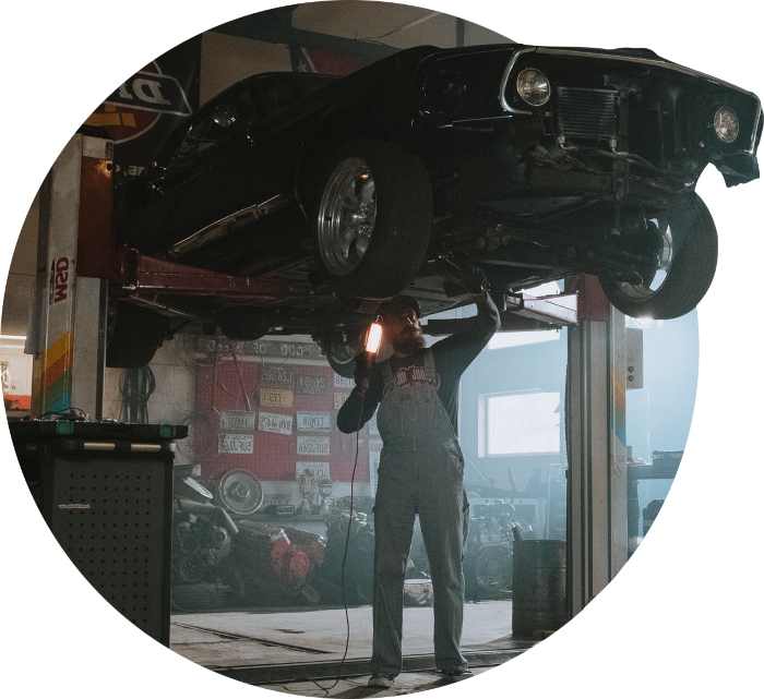 Black vehicle on a car lift equipment with a worker fixing it
